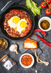 Shakshuka, Fried Eggs in Tomato Sauce in iron frying pan. Typical Israel food.