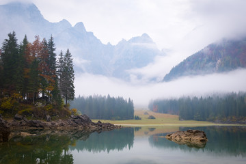 Lake Laghi di Fusine on foggy morning and mountain Mangart