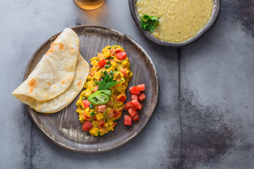 Indian Style scrambled eggs Akuri with paratha, dahl and ice tea, copy space
