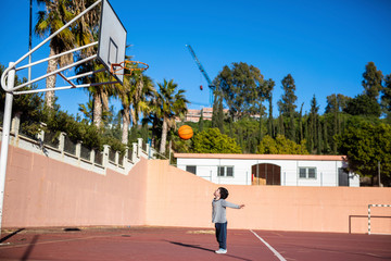 Child with his ball on the basketball court