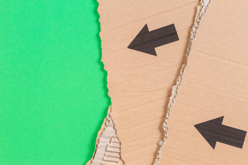 Brown corrugated cardboard ragged edge with black arrow on green background