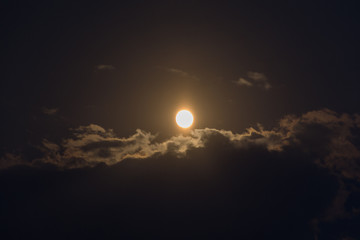 Moon through the clouds at night