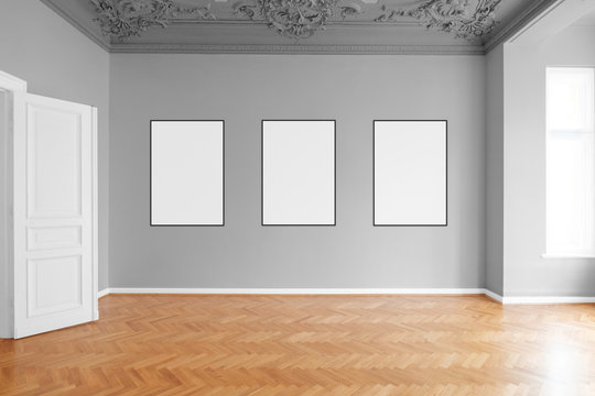  three blank picture frames hanging on wall in empty apartment  room  