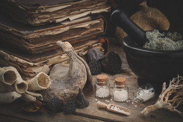 Bottles of homeopathic globules, mortar of dried moss, old books, dry roots, nuts and plants....