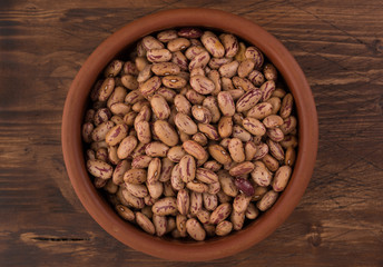 A plate of beans on wooden table background
