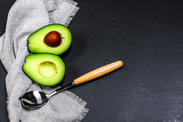 food background with fresh organic avocado on a grey stone table, top view, copy space