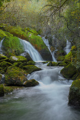 Fototapeta na wymiar waterfall with green rocks in long exposure