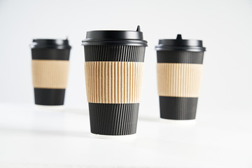 Three paper disposable coffee black cup for take away or to go, isolated on white, space for design layout.