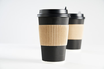 Two paper disposable coffee black cup for take away or to go, isolated on white, space for design layout.