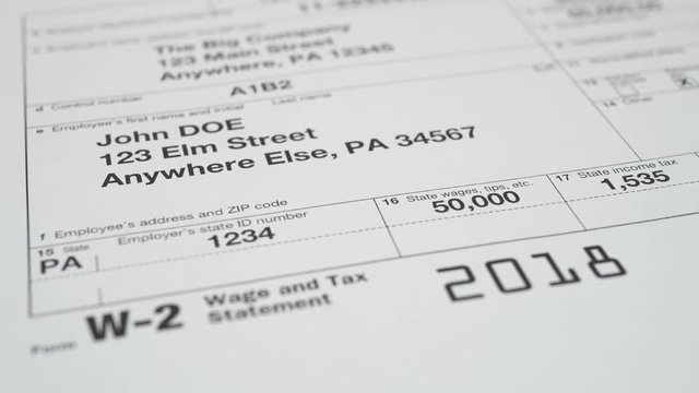 Tax document for the IRS W-2 Tax form on wooden table in office or at home