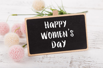 Small chalkboard for Women's day. Background with pink roses.