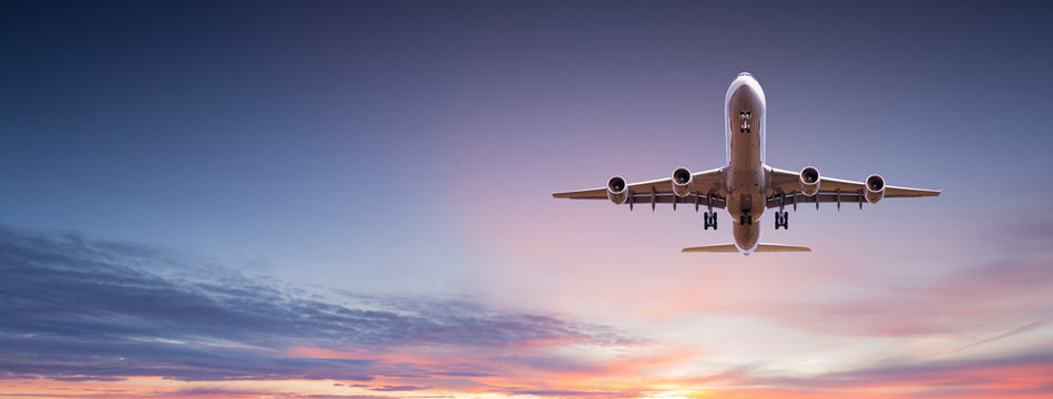 Fototapeta Komercyjny samolot odrzutowy latający nad dramatyczne chmury.