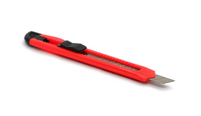 A red plastic knife with a retractable blade for paper isolated on a white background.