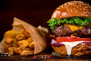 Tasty burger on wooden table. - obrazy, fototapety, plakaty