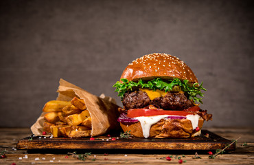 Tasty burger on wooden table. - obrazy, fototapety, plakaty