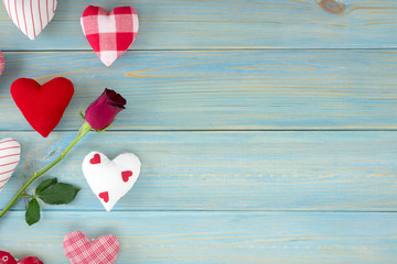 Valentines day romantic decoration with roses and hearts on a blue wooden table. Top view, copy space.