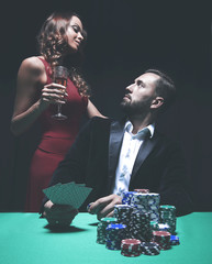 beautiful couple looking at playing cards at poker
