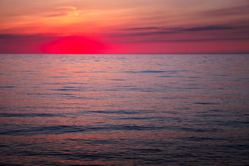 Naklejka na ściany i meble Beautiful sunset over the ocean. Sunrise in the sea