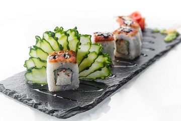 Sushi Roll dragon, on black stone, on white background, close up
