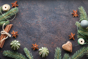 Obraz na płótnie Canvas Flat lay with fir twigs and Christmas decorations on dark with copy-space