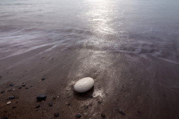 Fototapeta na wymiar white rounded stone washed by the waves