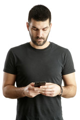 Portrait of a young man looking at his smartphone, studio shot isolated on white