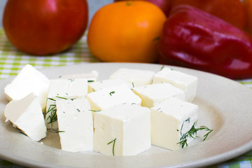 Fresh Greek Feta cheese. Healthy ingredient for salad. Crushed goat cheese with herbs. Pieces of feta cheese on a plate with dill greens