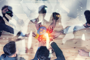 Business team connect pieces of gears. Photo from above. Teamwork, partnership and integration...