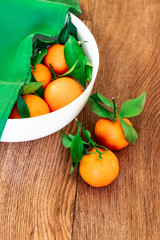 Fresh picked mandarins on a brown wooden table