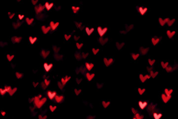 Fototapeta na wymiar Red heart valentine bokeh lights against a black background