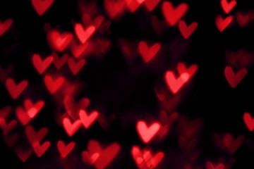 Fototapeta na wymiar Red heart valentine bokeh lights against a black background