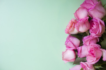 Pink roses on green background. Valentines day background. Top view with copy space