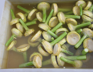 many artichoke stalks in fresh water ready to be cooked and eaten for sale at the fruit and vegetable market