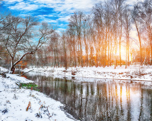 Winter landscape by a river in the sunset.
