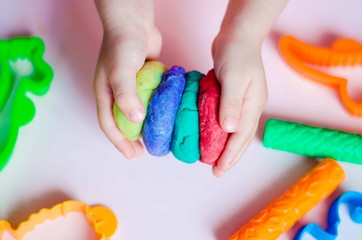 Child hands playing with colorful clay. Homemade plastiline