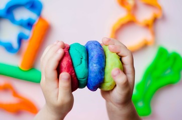 Child hands playing with colorful clay. Homemade plastiline