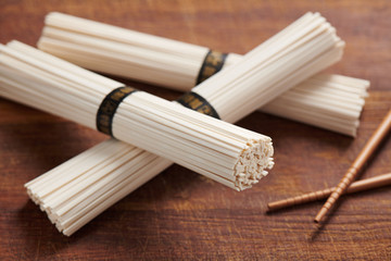 Pile of uncooked wheat udon noodles on chopping board, Oriental and Asian cuisine