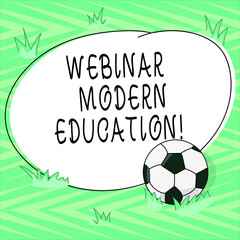 Text sign showing Webinar Modern Education. Conceptual photo process and practice of developing web application Soccer Ball on the Grass and Blank Outlined Round Color Shape photo