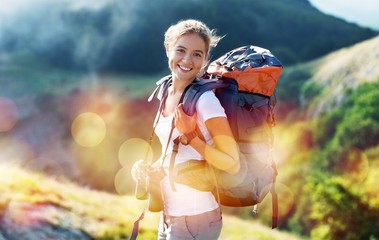 Woman with backpack trekking through the mountains