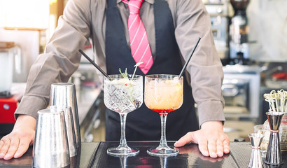 Young bartender making cocktails at bar counter - Barman serving drinks - Work, passion and mixologist concept