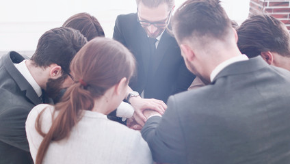 close up.a group of employees folded their hands together