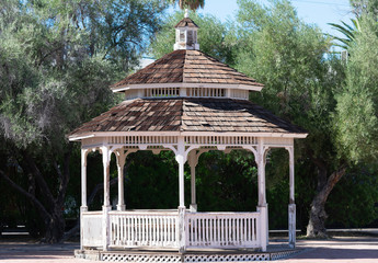 Wooden gazebo with stepped roof cover with cedar shingles