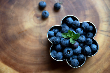 fresh blueberry on wooden background in a flower cookie cuter 