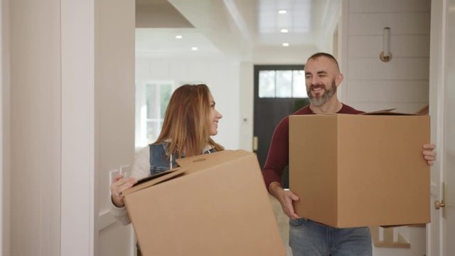 Young family moving into a new home they just bought. Couple brining boxes with stuff  / New start 