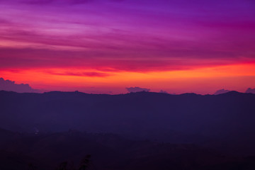 silhouette of mountains on orange and purple sky
