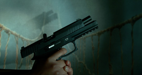 Hand cocking gun pointed upwards