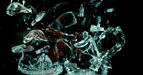 A Glass Measuring Cup Shattering, breaking, exploding into shards isolated on black. Fragments exploded out of form