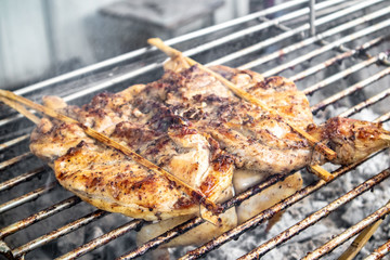 Thai whole chicken grilled with charcoal on street.