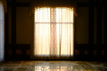 Curtain of window at wall with dusk sunlight