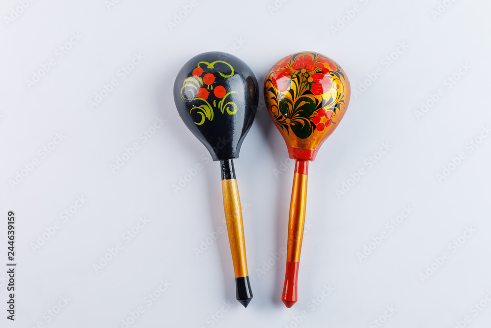 Wall mural Two spoons with a traditional pattern. Wooden spoons with floral ornament in traditional folk Russian Khokhloma style on a wooden background.